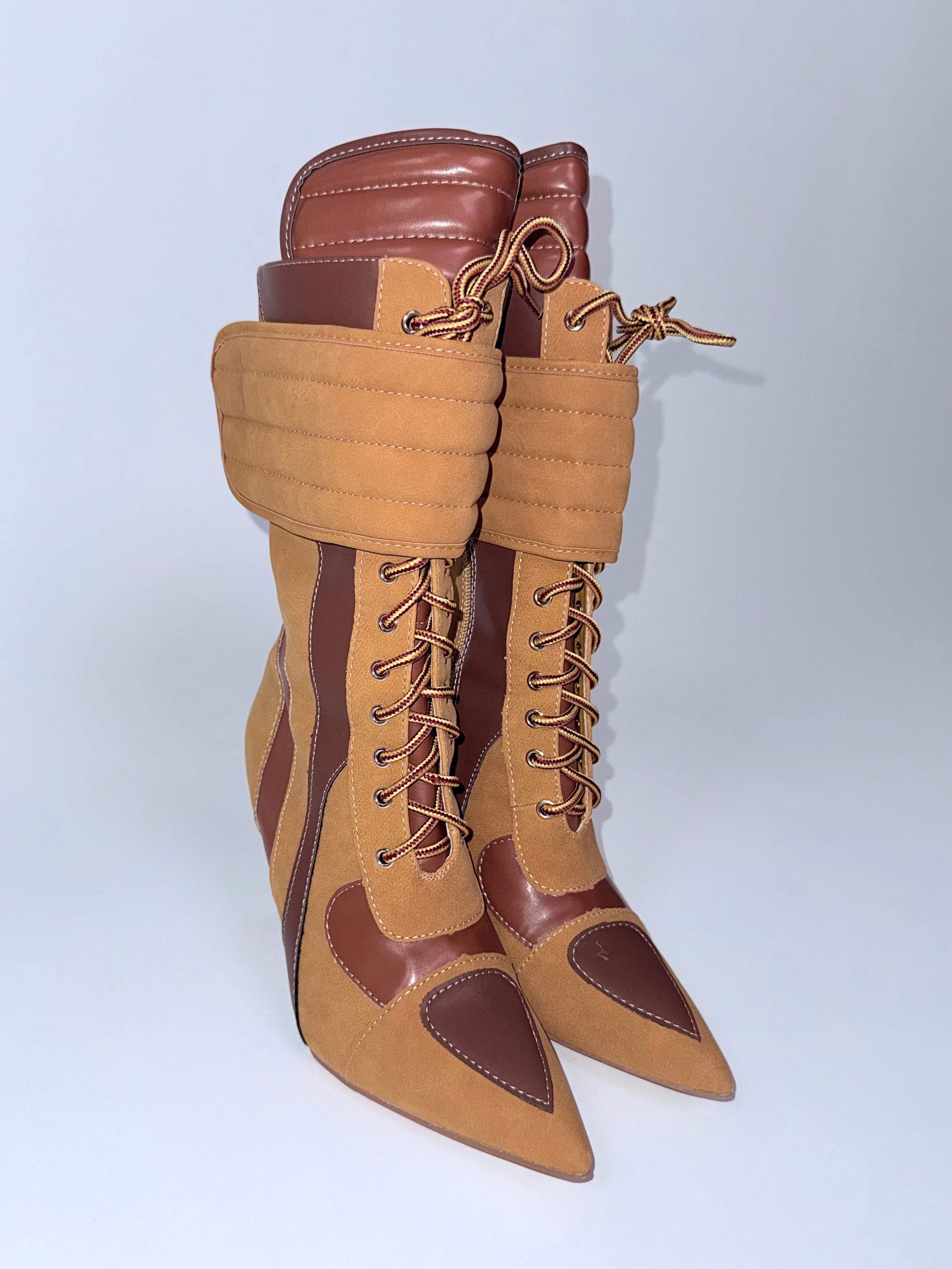 Tan and brown lace-up boots on a white background