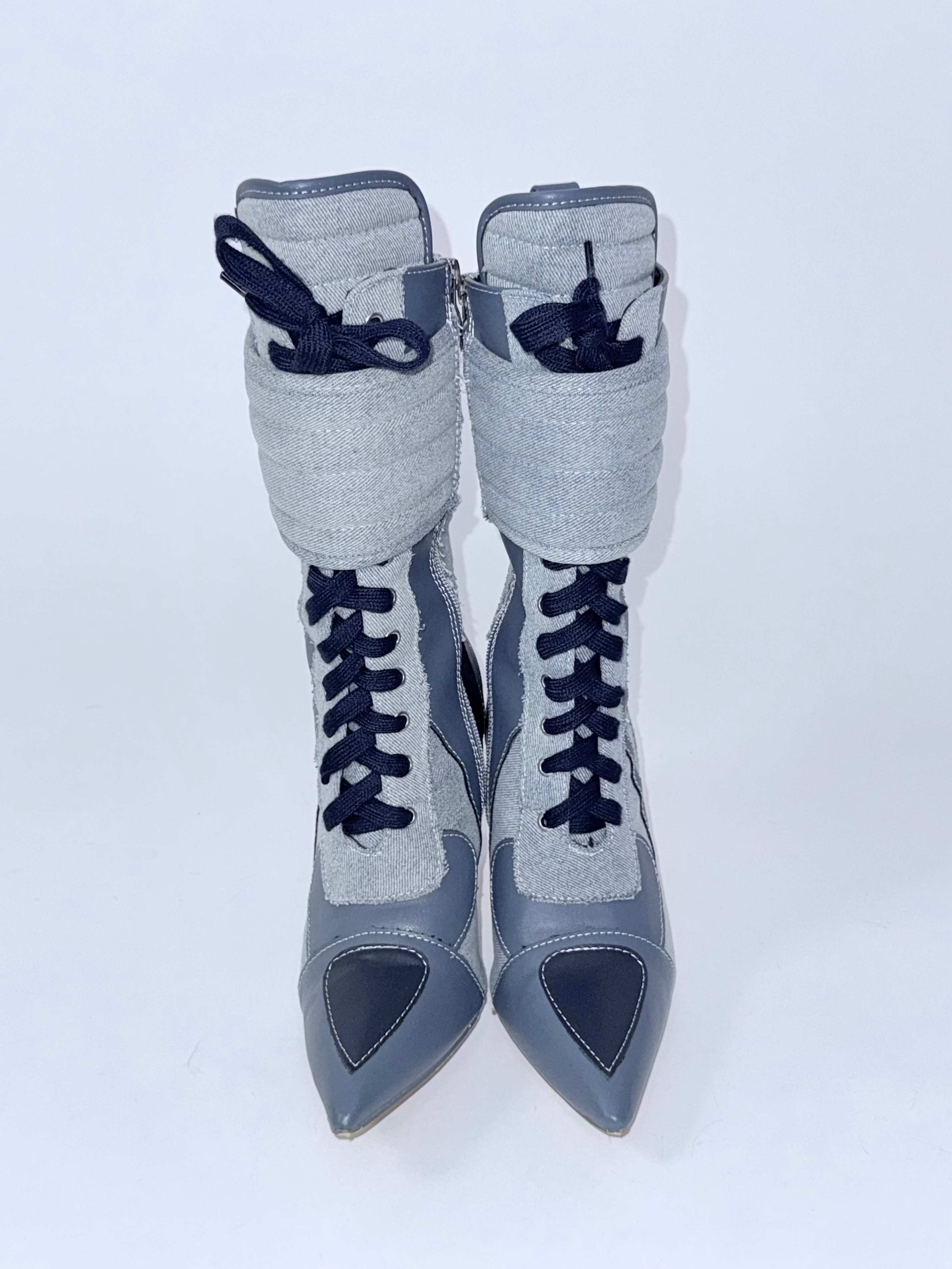 Pair of blue high-heeled shoes with navy accents on a white background