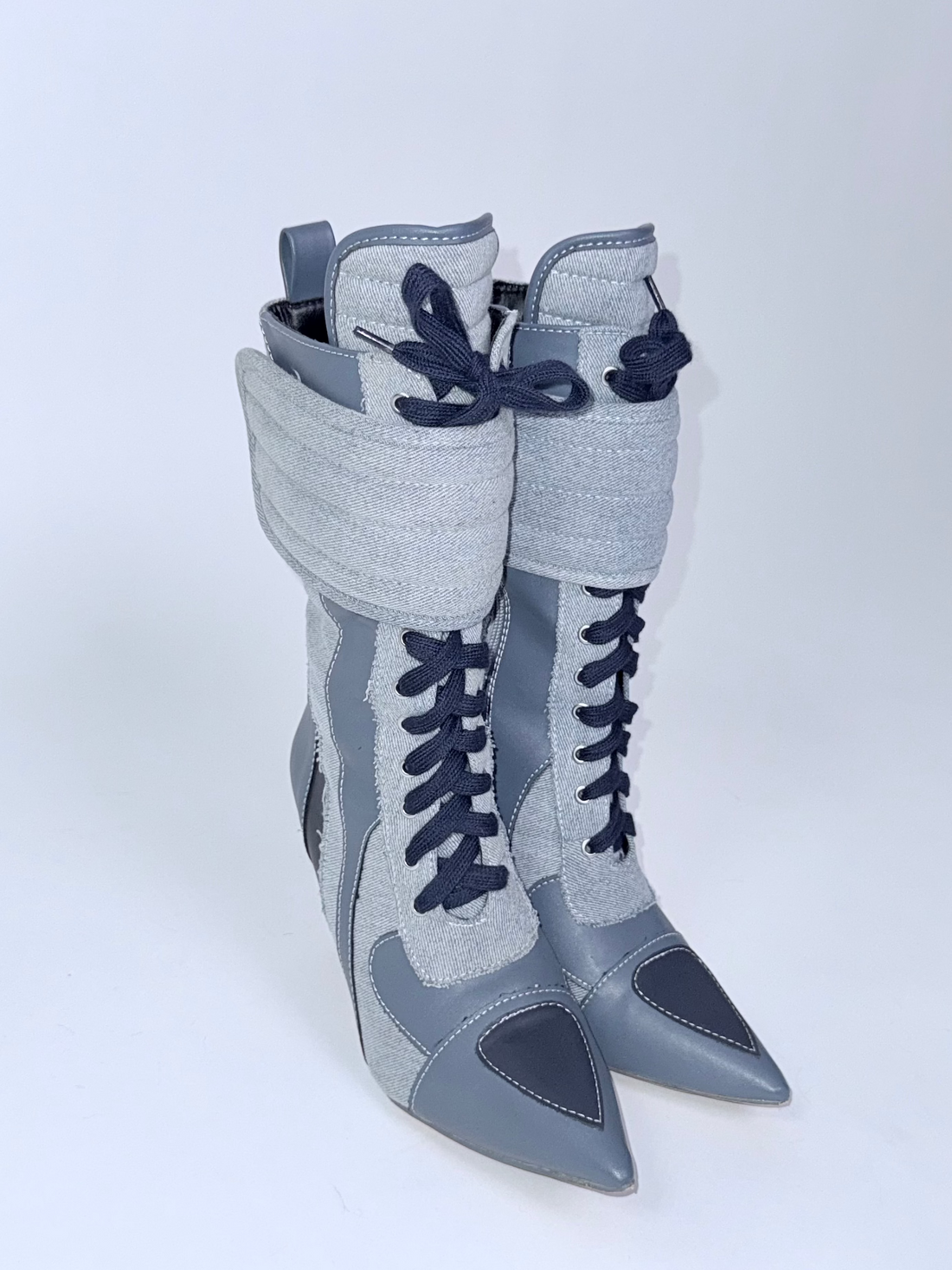 Pair of blue and blue high-heeled boots with laces on a white background
