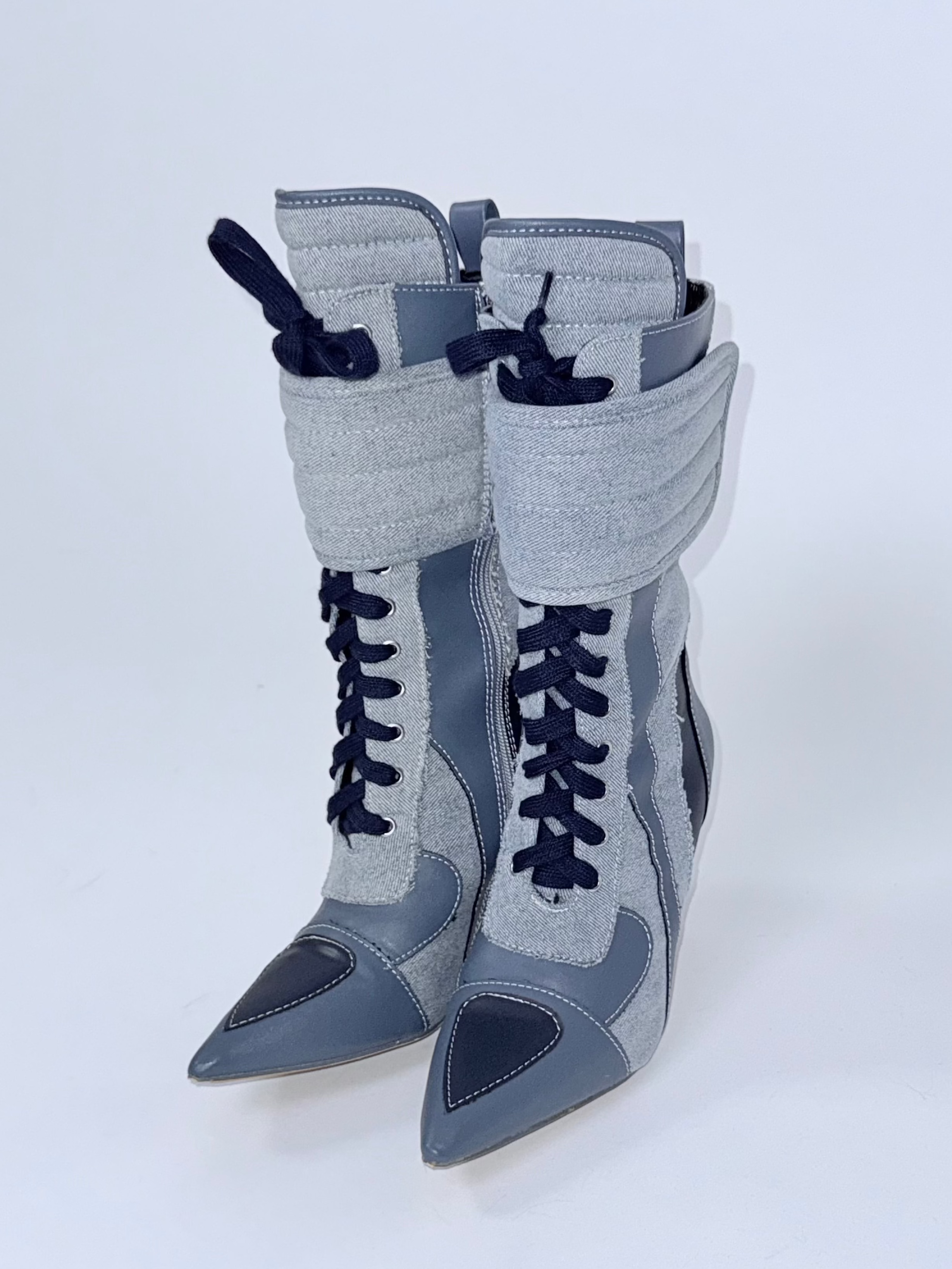 Blue high-heeled boots with navy accents on a white background